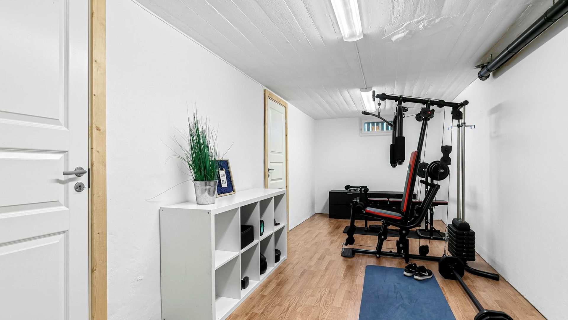 Home gym with a weight rack, dumbbells and exercise equipment set up and ready to use