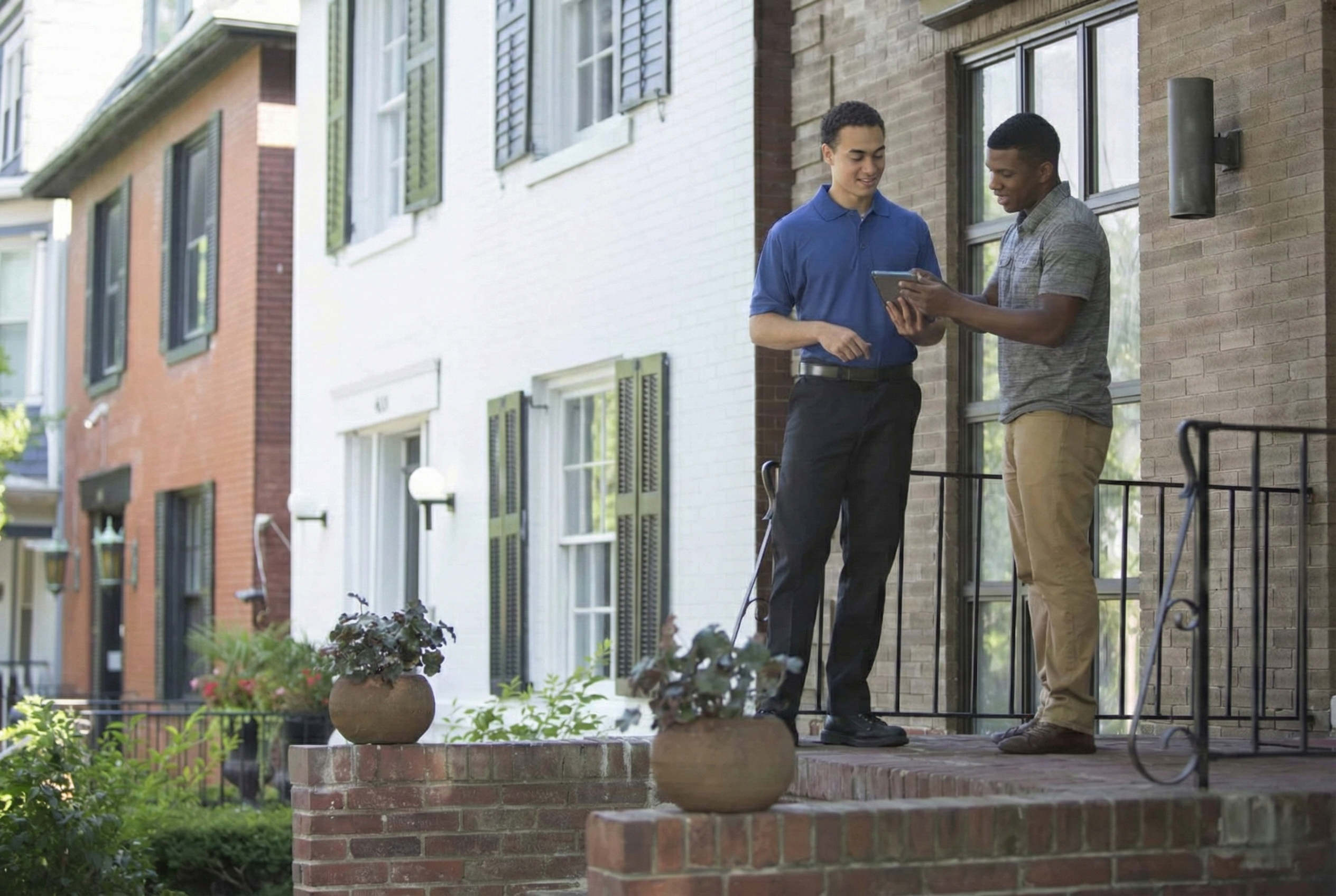 Next Phase Moving movers talking to a client outside a house.